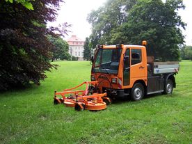 Große orange Maschine beim Rasenmähen