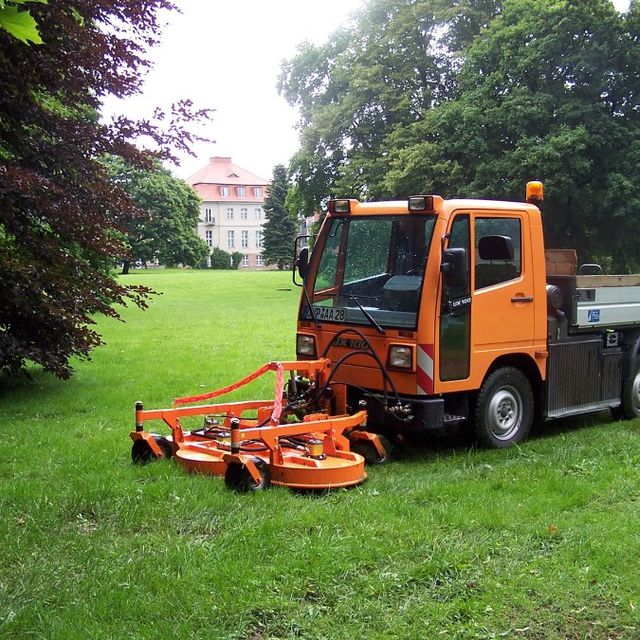 Große orange Maschine beim Rasenmähen