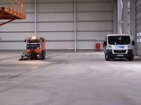 Ein Transporter und eine Maschine in einer großen Garagenhalle