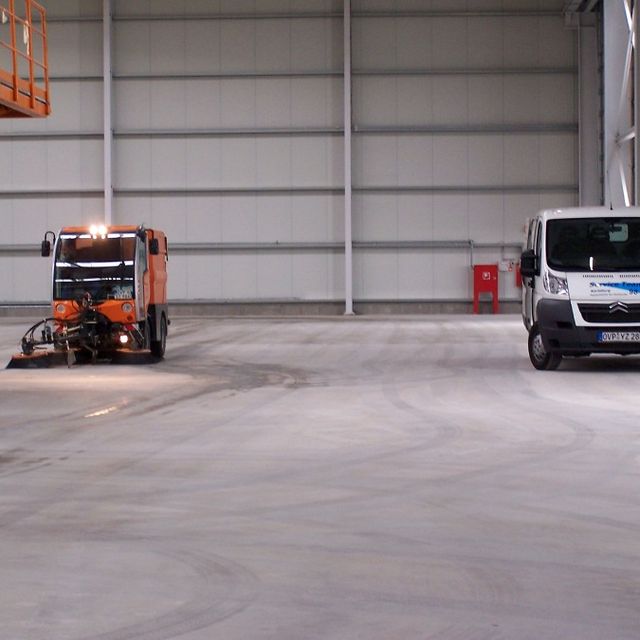 Ein Transporter und eine Maschine in einer großen Garagenhalle