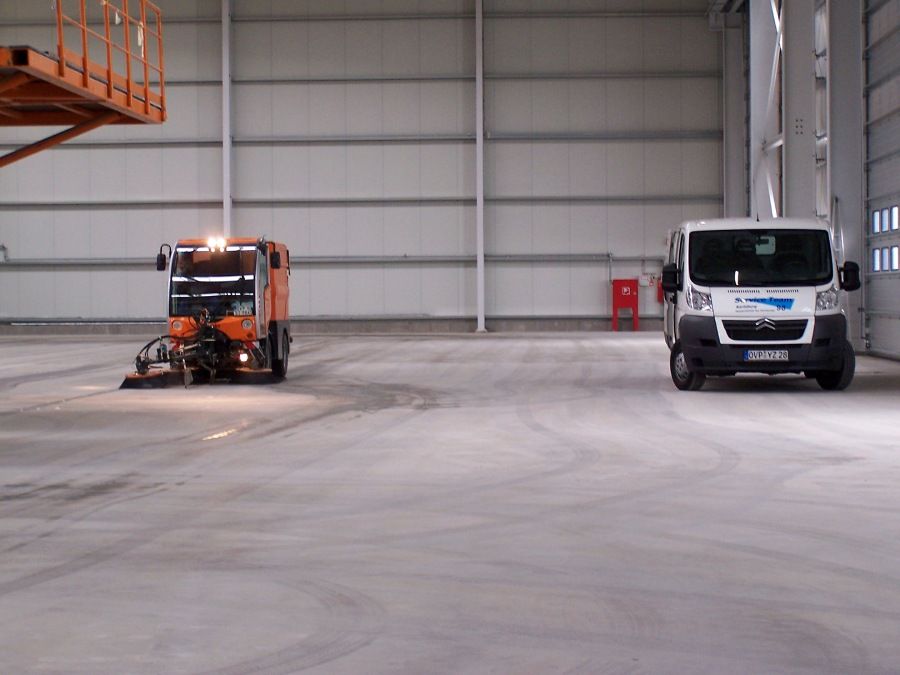 Ein Transporter und eine Maschine in einer großen Garagenhalle